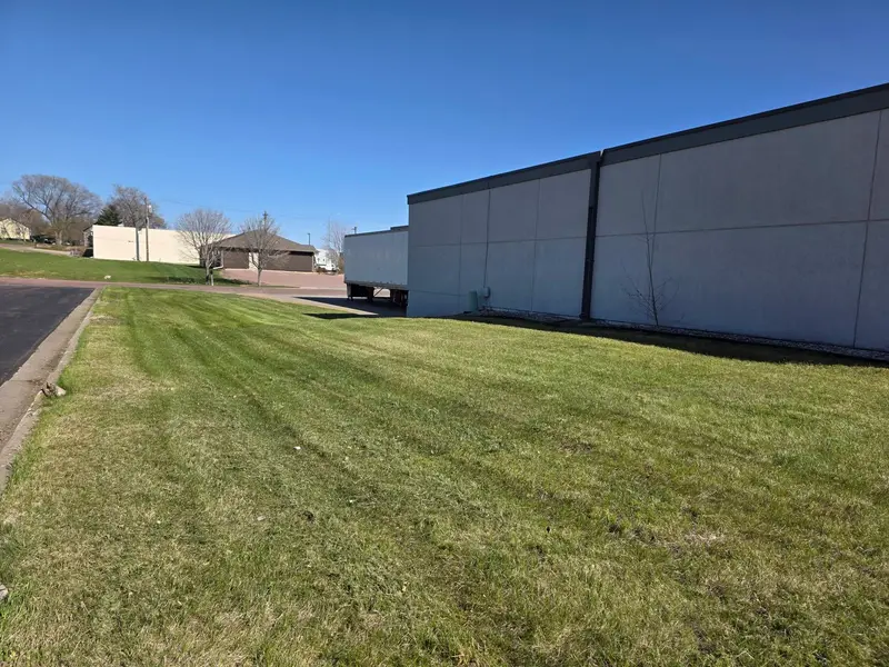 A long strip of mown lawn beside a commercial building