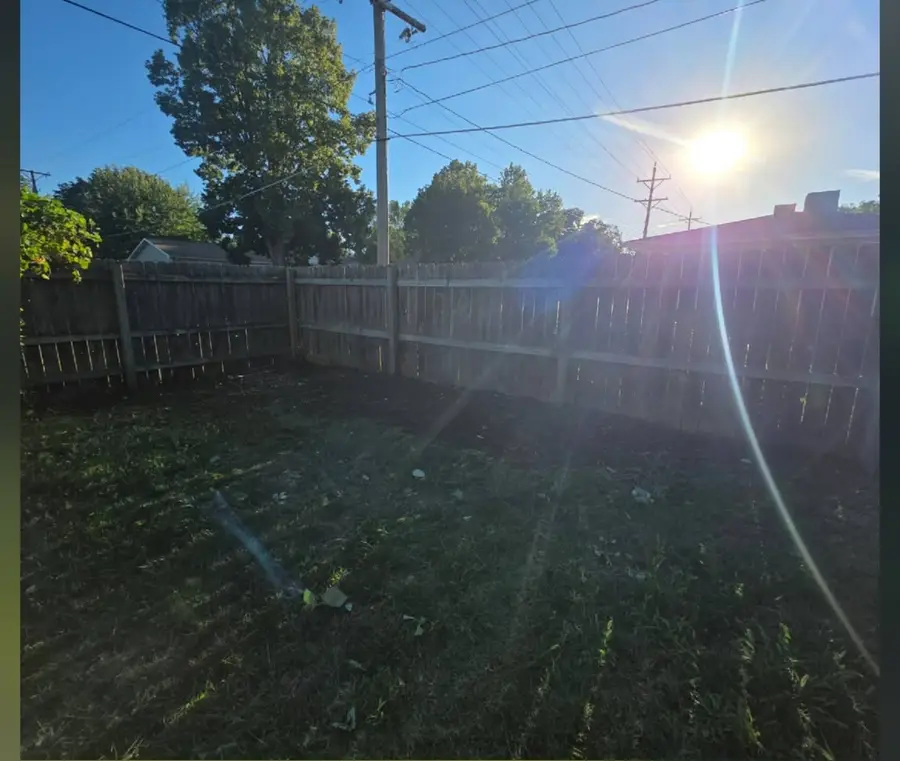 The same fence line cleared back to bare grass, after
