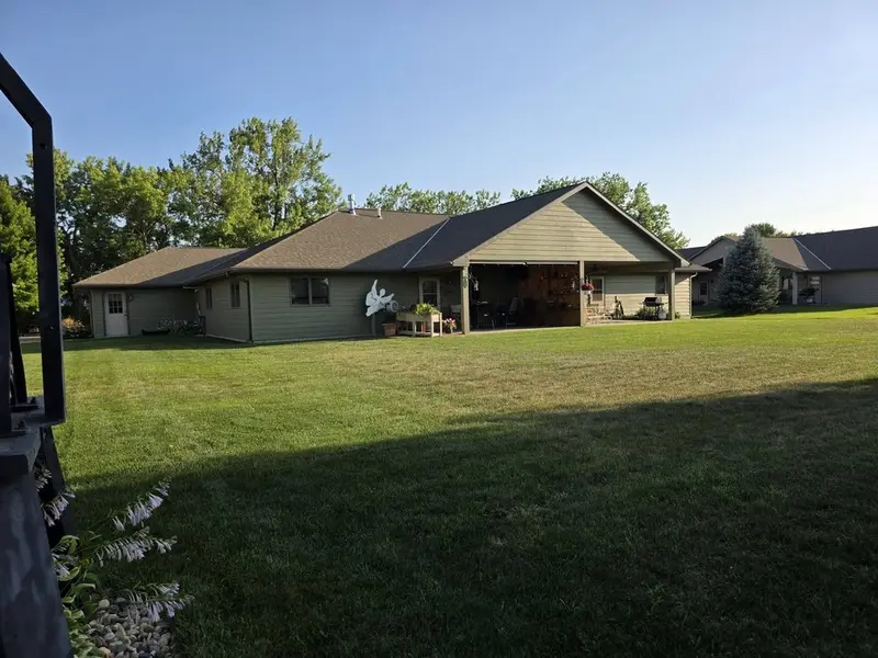 A large open backyard mown behind a ranch-style home